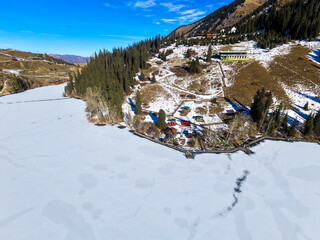 Aerial view of the western part of Lake Kolsay. Observation deck on the shore. Kegen District, Kazakhstan. January 3, 2026.