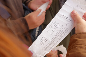 神社のおみくじで運勢を占う女性の手元