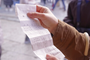 神社のおみくじで運勢を占う女性の手元