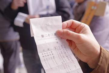 神社のおみくじで運勢を占う女性の手元