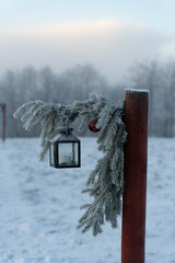 A Christmas lantern decoration on a walkway pole on a freezing sunny and foggy winter day.