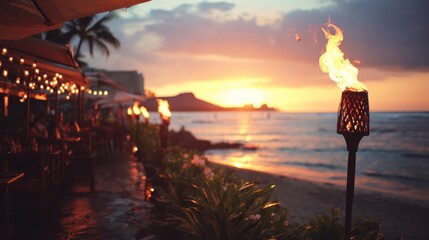 Beachside dining at sunset with tiki torch. The ocean and sky glow in vibrant colors