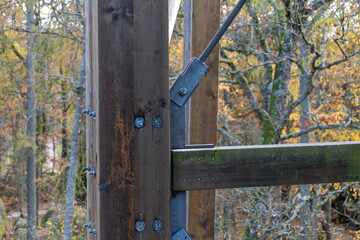 A wooden beam connected to metal elements of the supporting structure.