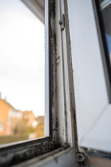 Dirty plastic window. Dust-covered plastic window frame and sill with dirt buildup and stains. Spring home cleaning concept