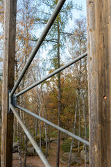 Diagonal metal pipes fixed in the wooden supporting structure of the observation tower.
