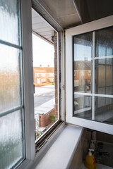 Dirty plastic window. Dust-covered plastic window frame and sill with dirt buildup and stains. Spring home cleaning concept