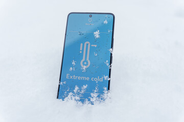 Smartphone screen showing low temperature thermometer lying in snow outdoors, extreme cold concept