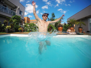 homem em piscina transparente no ver&atilde;o , paisagismo tropical
