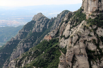 Naklejka premium Rocky peaks of Montserrat with historic chapels and churches perched among the cliffs, in Catalonia, Spain, taken in July 2024.