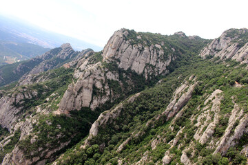 Fototapeta premium Rocky peaks of Montserrat with historic chapels and churches perched among the cliffs, in Catalonia, Spain, taken in July 2024.