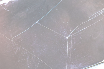 Broken glass on transparent background with lots of glass splinters and cracks