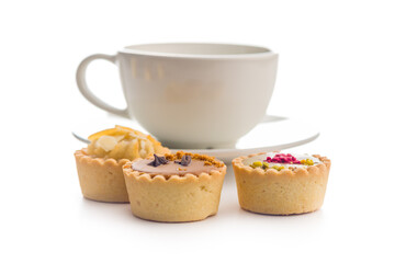 Sweet mini tartlets and coffee cup isolated on white background.