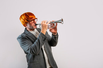 Adult man wearing orange wig playing trumpet