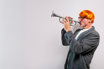 Man wearing orange wig playing trumpet