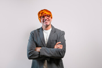 Man wearing orange wig and glasses smiling with arms crossed