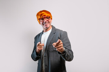 Mature adult man wearing orange wig pointing finger