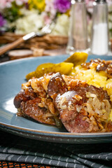 Turkey liver with mashed potato and pickled cucumber.