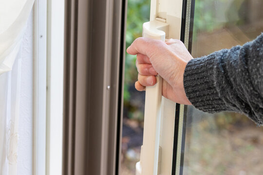 ガラス戸の取っ手を握って開け閉めする