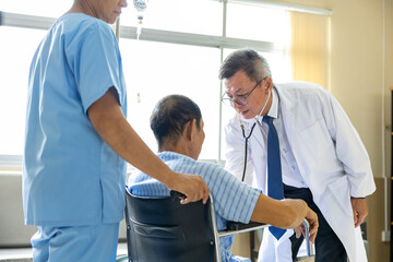 Doctor and nurse are examining patient knee in the wheelchair after operation surgery for rehabilitation and physical therapy and recovery process