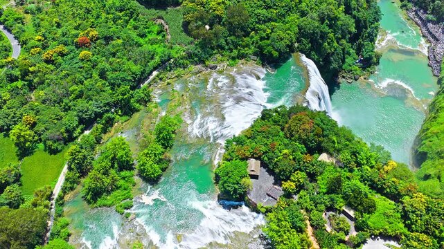 The famous Huangguoshu Waterfall natural landscape in Guizhou, China. Aerial shot of a majestic waterfall cascading into a green river surrounded by lush forest in summer.