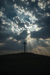 Silhouette of Christian cross against dramatic cloudy sky, faith concept.