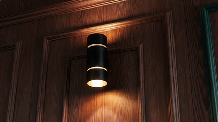 Sleek black cylinder wall light illuminated on classic dark wood paneling texture with decorative molding creating sophisticated elegant interior design mood with warm golden glow and shadows