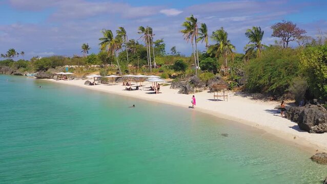 Tropical beach with palm trees along island coastline, Philippines, 2019