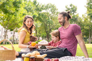 Happy family spending time on holiday. mother, father and little son having picnic in nature on a summer day. Leisure, summer, childhood concept.