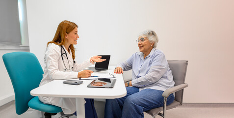 Female ophthalmologist describing eye treatment and medical procedure to old patient in hospital office