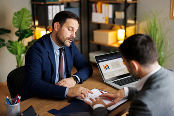 Businessman discussing contract details with partner in the office