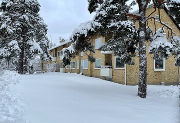 Sweden. A two-story house surrounded by snow-covered trees on a cool winter morning.