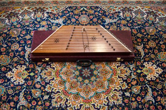 Iranian Santoor (a musical instrument) on a Persian carpet.