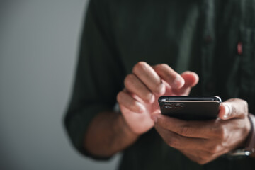 Close-up of a person's hands holding a smartphone, with their fingers touching the screen. The background is out of focus.