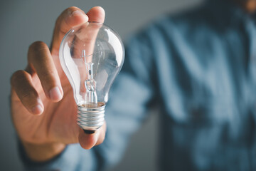 Close-up of a hand holding a lightbulb, symbolizing a new idea or solution. The background is blurred, leaving the lightbulb as the focal point. .