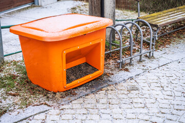 Container with sand or  gravel used in winter to sprinkle sidewalks, streets and parking lots. Preparation of the city to ensure safety.
