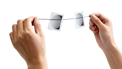Closeup of hands holding convergence cards on a string against a white backdrop demonstrating orthoptic eye coordination exercises for vision improvement.