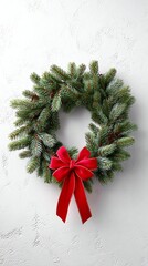 A festive green wreath adorned with a vibrant red bow, perfect for holiday decoration.