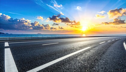 Open road leading towards the ocean at sunset with vibrant blue sky and clouds, promising adventure and travel