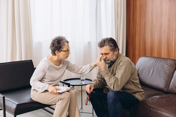Psychologist comforting crying man during therapy session