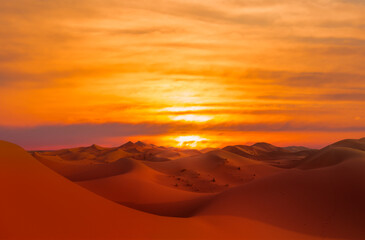 Naklejka premium Sand dunes in the Sahara Desert at amazing sunrise, Merzouga, Morocco - Orange dunes in the desert of Morocco - Sahara desert, Morocco