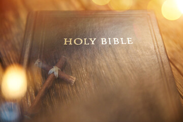 Overlapping the Holy Bible and the cross of Jesus Christ, symbolizing his death and resurrection
