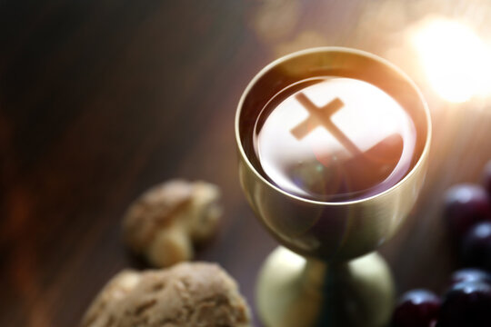 The Holy Communion bread and wine symbolizing the holy blood and body of Jesus Christ, the cross, and the Last Supper background
