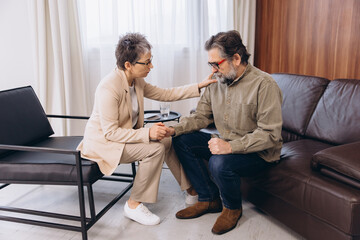 Psychologist supporting senior man during counseling session