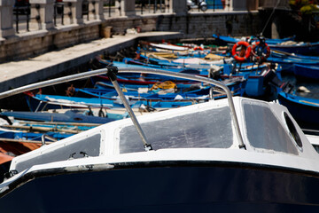 Docked fishing boats in harbor with close-up of cabin cruiser
