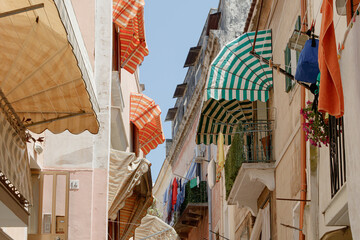 Striped window awnings and laundry in Mediterranean alley