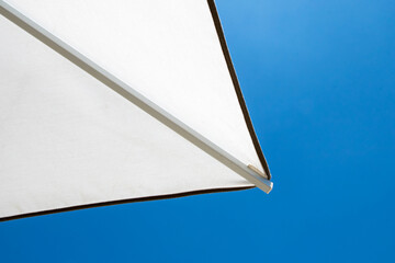Minimal view of white beach umbrella against blue sky