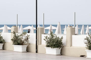 Beachfront terrace with white umbrellas and sea view