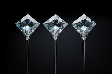 Three sparkling diamonds standing on thin metal holders against a black background