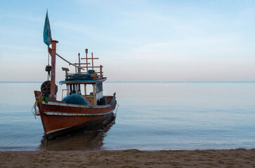 Traditional fishing boats resting on a quiet sandy beach under natural daylight, reflecting coastal life and local culture.