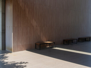 Long wooden bench placed on the floor against a wooden wall, showcasing a simple and rustic interior design.